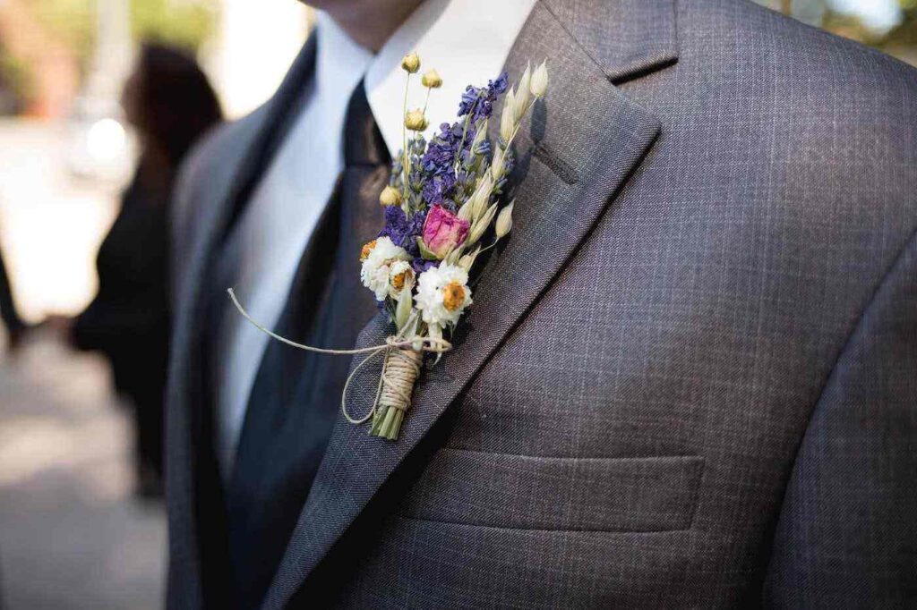 boutonniere su giacca grigia - quali fiori scegliere per il matrimonio