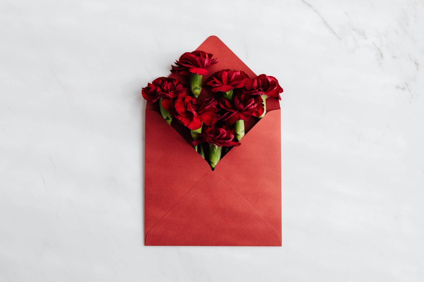 red envelope with red carnations inside - what flowers to get for each anniversary