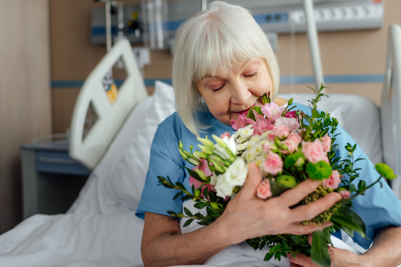 old smiling woman hugging a bouquet of flowers - (image credit: Alla Serebrina)