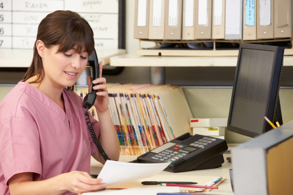 Nurse Making Phone Call At Nurses Station - how to send flowers to a hospital in 3 easy steps